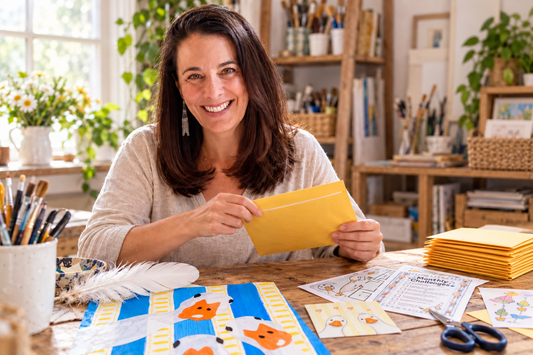 Jenny Carroll packing Happy Mail envelopes with art projects, creative activities, stickers, and small surprises.